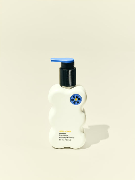 Front solo packshot of Happy Medium 8.5 oz bottle against a beige background